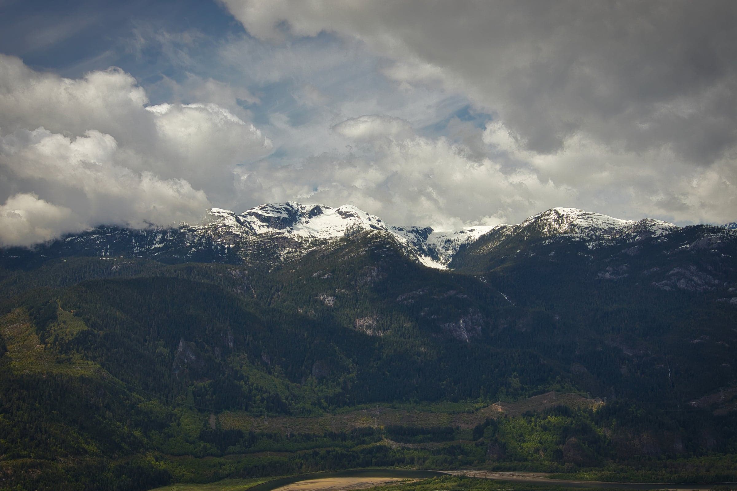 Snowy mountain ridges under a heavy cloud bank.